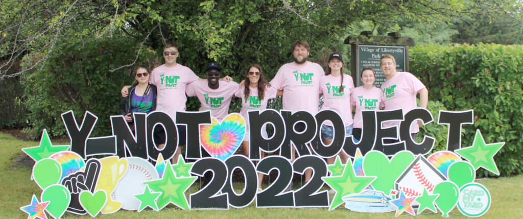 Participants pose in pink t-shirts at the Y-noT Project 2022 event.